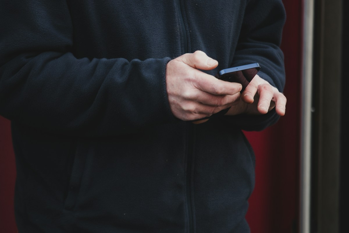 Conta laranja: mãos segurando celular usado em golpe do Pix