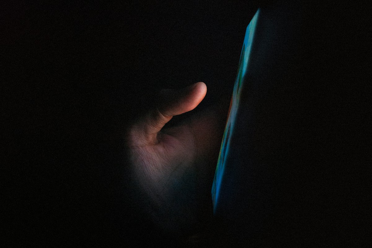 Golpe do saldo das bets: pessoa usando o celular no escuro